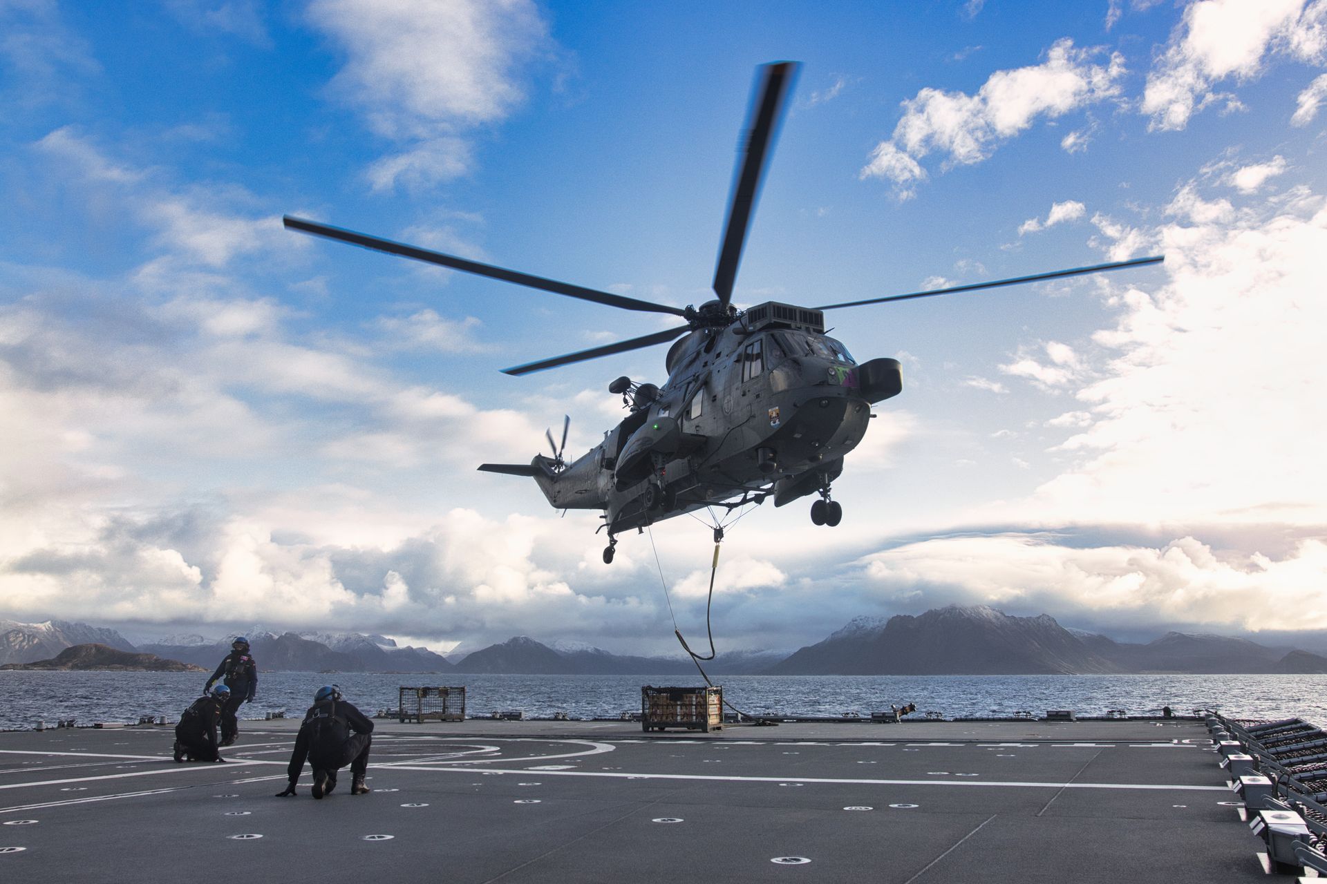 Navy helicopter hovering over a ship deck